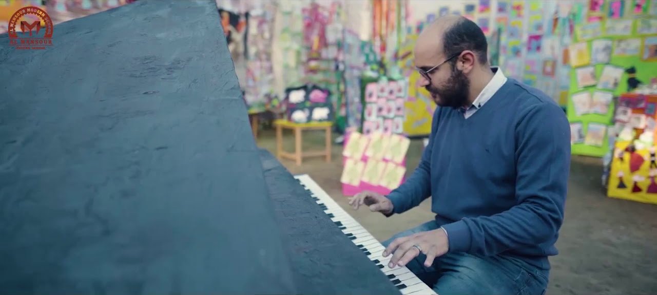 A music lesson at Al Mansour Modern School beside a wall of children's artwork